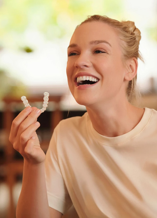 Patient holding a SPARK clear aligner at Bespoke Dental
